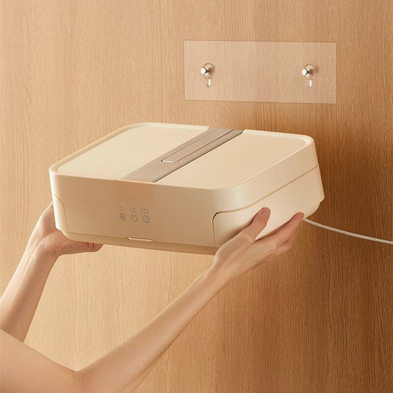 Portable electric clothes dryer held against a wooden wall